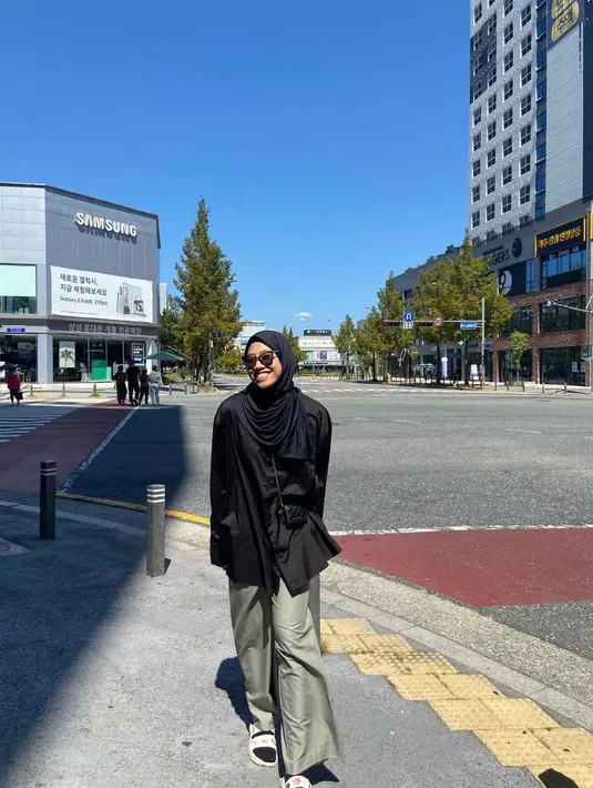 Ada kalanya Mega tampil santai dengan kemeja panjang hitam dan loose pants warna hijau . Ia melengkapi penampilannya dengan micro bags dan sandal. [@megawatihangestrip]