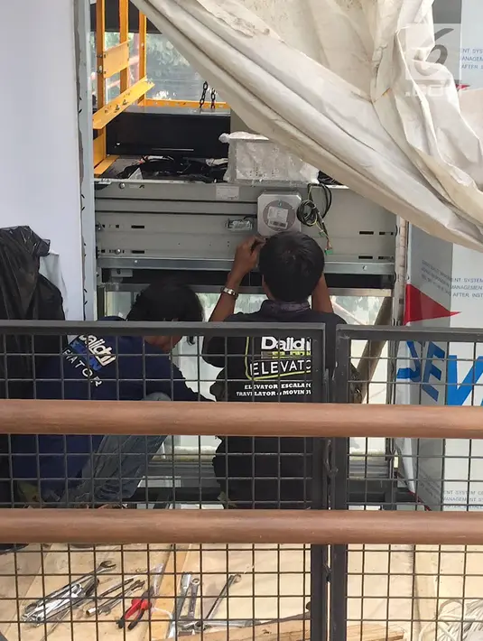 Pekerja menyelesaikan pembangunan lift pada jembatan penyeberangan orang di kawasan Senayan, Jakarta, Senin (13/5). Pembangunan lift pada tiga JPO yang berada di Jalan Sudirman itu bertujuan meningkatkan kenyamanan kepada warga dan ditargetkan rampung akhir bulan ini.(Liputan6.com/Immanuel Antonius)