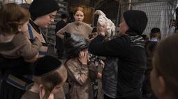 Seorang wanita Yahudi ultra-Ortodoks mengayunkan seekor ayam di atas kepala putrinya sebagai bagian dari ritual Kaparot di Yerusalem, Minggu (2/10/2022). Orang-orang Yahudi yang taat percaya bahwa ritual tersebut memindahkan dosa seseorang dari tahun lalu ke dalam ayam, dan dilakukan sebelum Hari Pendamaian, Yom Kippur, hari paling suci dalam tahun Yahudi yang dimulai saat matahari terbenam. (AP Photo/Oded Balilty)