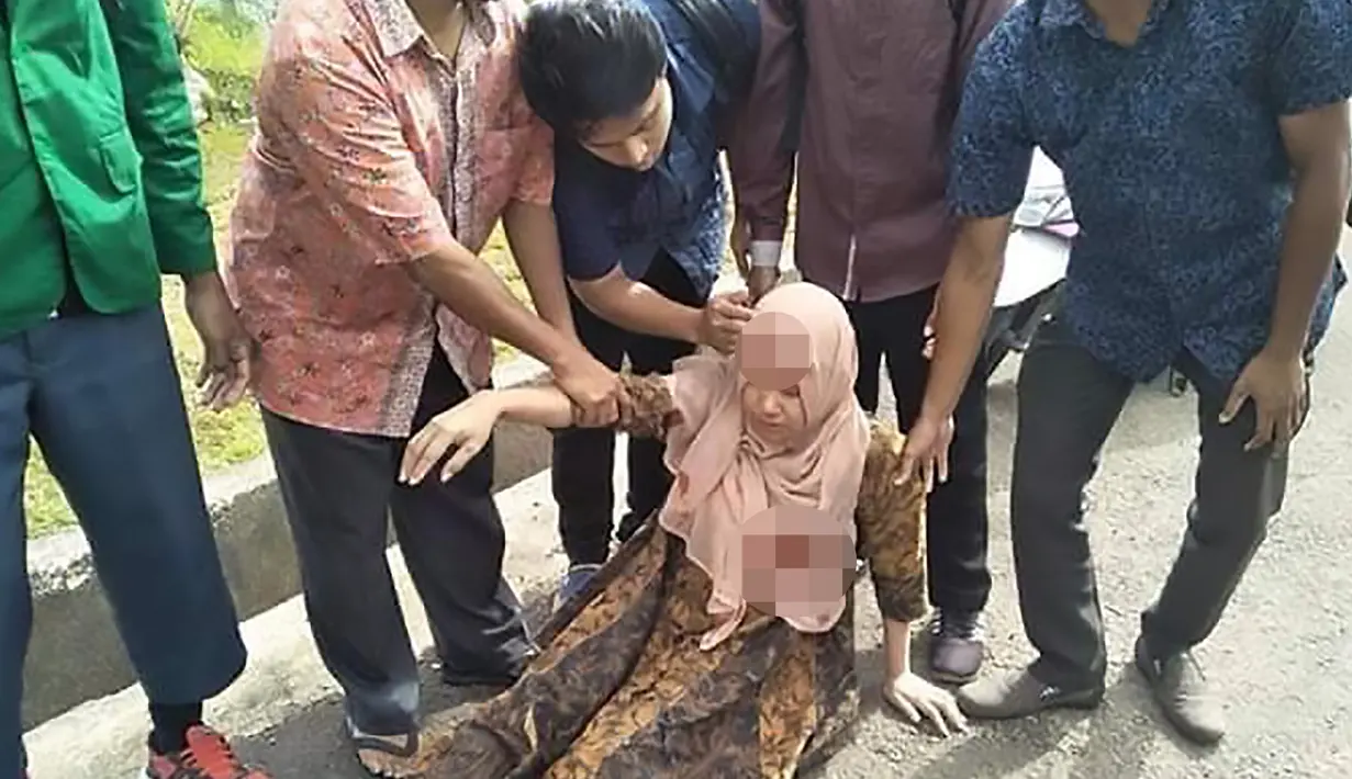 Warga membantu seorang wanita yang terluka setelah gempa berkekuatan 6,8 di Ambon, kepulauan Maluku (26/9/2019). Gempa magnitudo 6,8 diikuti gempa susulan magnitudo 5,6. Kemacetan sempat terjadi setelah gempa. (AFP Photo/Yusnita)