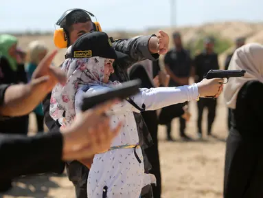 Seorang wanita Palestina berlatih menembak di Khan Younis di Jalur Gaza, Minggu (24/7). Pelatihan menembak tersebut dilatih langsung oleh anggota Perlindungan dan Keamanan Hamas. (REUTERS/ Ibraheem Abu Mustafa)