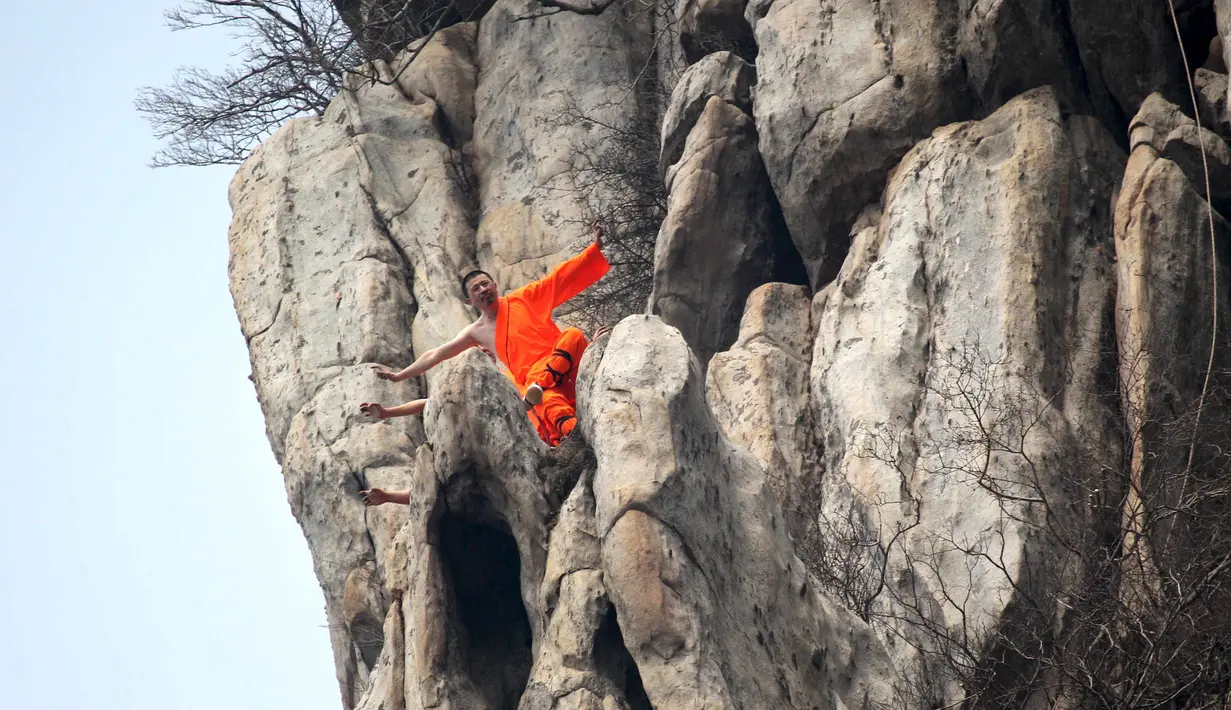 Sejumlah murid dari sekolah bela diri berlatih kungfu shaolin di ujung tebing gunung  Songshan, , China , (17/3). Tanpa dibekali alat keamanan, Para murid ini melakukan gerakan ekstrem di tebing gunung. (REUTERS / China Daily)