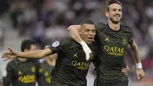 Pemain Paris Saint-Germain (PSG), Kylian Mbappe, melakukan selebrasi bersama Fabian Ruiz setelah mencetak gol ke gawang AJ Auxerre pada laga Liga Prancis, di Stade de I’Abbe Deschamps, Senin (22/5/2023). PSG menang dengan skor tipis 2-1. (AP Photo/Thibault Camus)