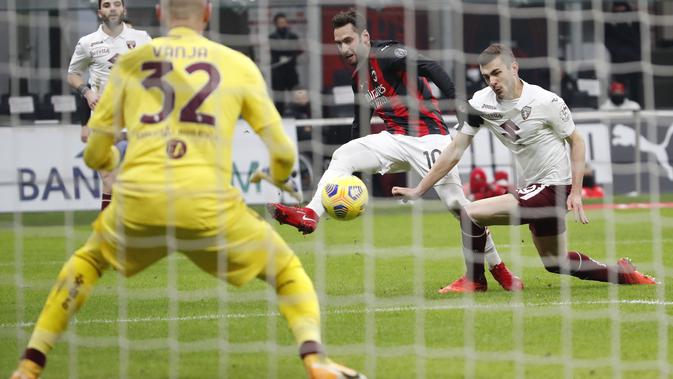 Gelandang AC Milan, Hakan Calhanoglu (tengah) berusaha mencetak gol ke gawang Torino pada babak 16 besar Coppa Italia 2020/2021 di San Siro, Rabu (13/1/2021) dini hari WIB. Laga terkunci 0-0, AC Milan menang 5-4 atas Torino di babak adu penalti. (AP Photo/Antonio Calanni)