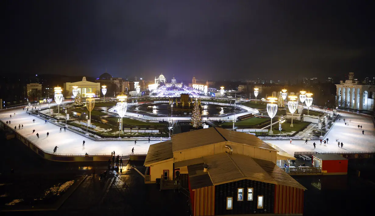 Suasana saat sejumlah orang berseluncur dalam pembukaan arena seluncur es di VDNKh (Pameran Prestasi Ekonomi Nasional), Moskow, Rusia, Jumat (27/11/2020). Area tersebut terbuat dari lapisan es buatan lebih dari 20.000 meter persegi. (AP Photo/Alexander Zemlianichenko)