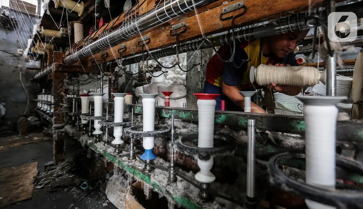 Pekerja memintal benang di Kebayoran, Jakarta, Selasa (5/7/2022). Pabrik benang yang berdiri sejak tahun 1970-an tersebut dapat memproduksi 100 kilogram benang dalam sehari dan dipasarkan ke berbagai daerah di Indonesia. (Liputan6.com/Johan Tallo)