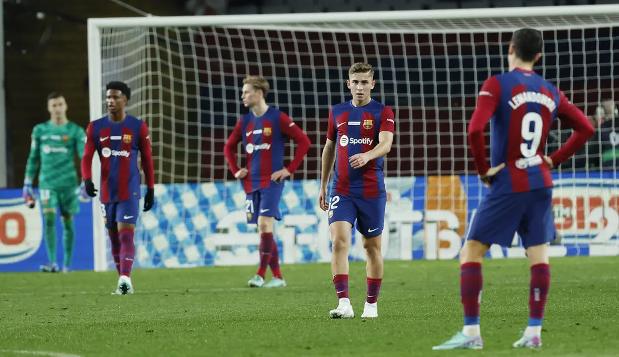 Para pemain Barcelona tampak kecewa setelah ditaklukkan Girona dalam laga La Liga 2023/2024 jornada 16 di Stadion Olimpic Lluis Companys, Senin (11/12/2023). (AP Photo/Joan Monfort)