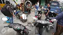 Seorang juru tambal ban saat memasang pentil salah satu pengendara yang terkena operasi cabut pentil di Jalan Kyai Tapa, Roxy, Jakarta, Jumat (23/10/2015). Para pengendara dicabut pentil motornya karena parkir sembarangan. (Liputan6.com/Immanuel Antonius)