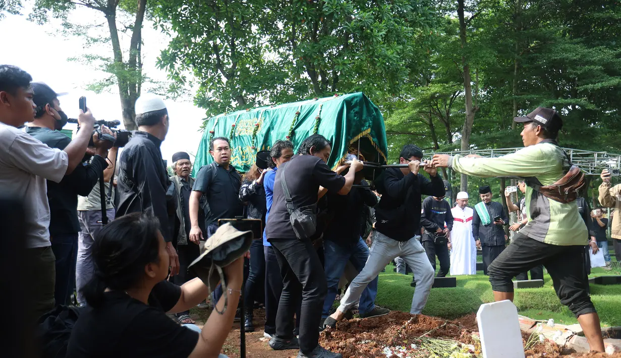 Isak tangis keluarga dan kerabat turut mengantarkan almarhum ke peristirahatan terakhir. Tampak dalam foto, kerabat dan keluarga membawa jenazah Epy Kusnandar di Tempat Pemakaman Umum (TPU) Jeruk Purut, Jakarta Selatan, Kamis (4/12/2025) pagi. (Kapanlagi.com/Budy Santoso)