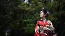 Gambar pada 21 Oktober 2019 menunjukkan seorang perempuan mengenakan pakaian tradisional Jepang, kimono, saat mengunjungi kuil Senso-ji di Tokyo. Sensoji Temple merupakan salah satu kuil tertua di Jepang yang terletak di Asakusa. (Anne-Christine POUJOULAT / AFP)