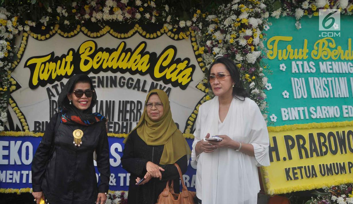 Warga berdiri di depan karangan bunga sekitar tempat persemayaman Ani Yudhoyono di Puri Cikeas, Bogor, Jawa Barat, Minggu (2/6/2019). Ani Yudhoyono akan dimakamkan di samping pusara istri presiden ke-3 RI BJ Habibie, Ainun Habibie.(Liputan6.com/Immanuel Antonius)