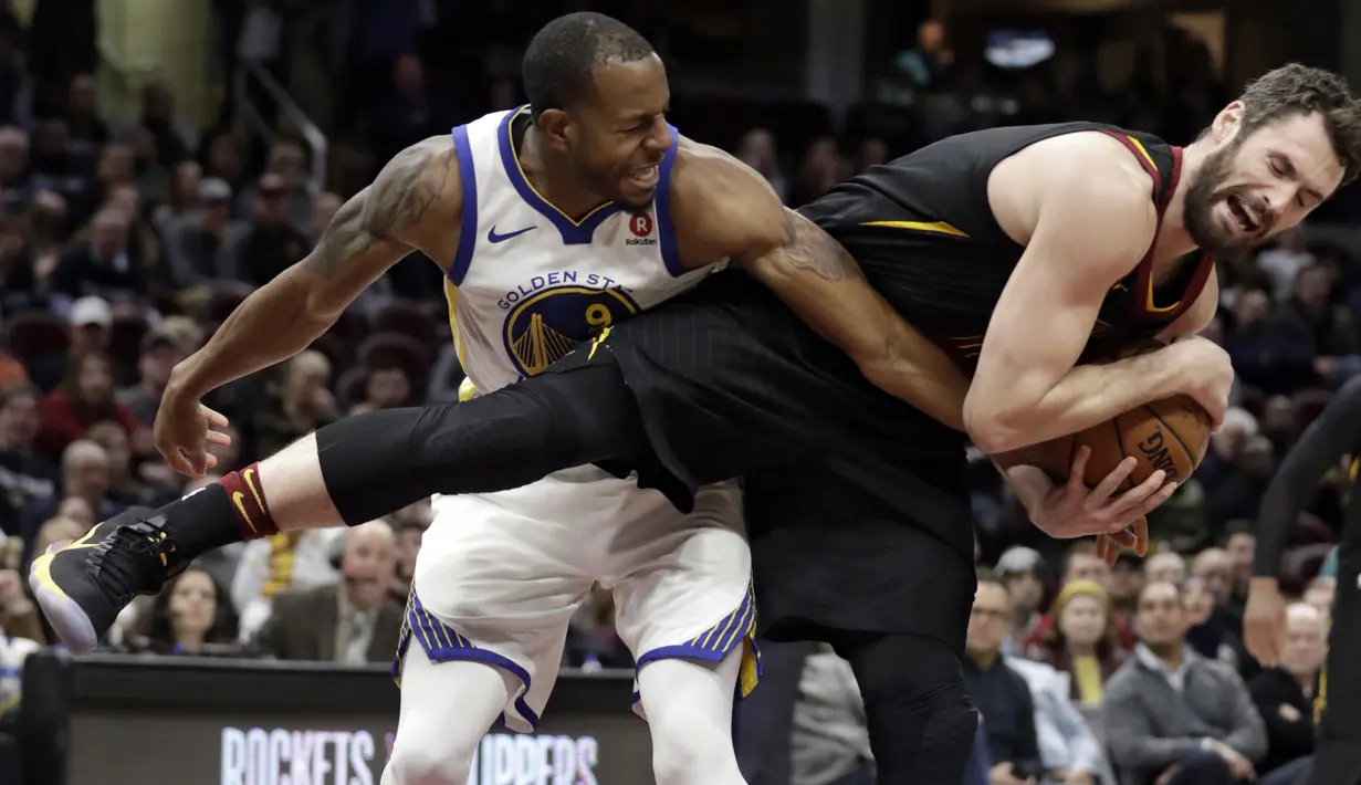 Aksi pemain Cleveland Cavaliers, Kevin Love (kanan) mengamankan bola dari kejaran pemain Warriors, Andre Iguodala pada lanjutan NBA basketball game di Quicken Loans Arena, Cleveland, (15/1/2018). Warriors menang 118-108. (AP/Tony Dejak)