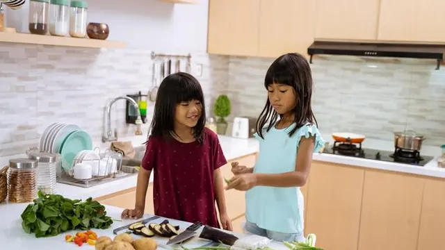 Dua orang anak perempuan sedang membantu memasak di dapur (Foto Dok: Freepik/EyeEm)