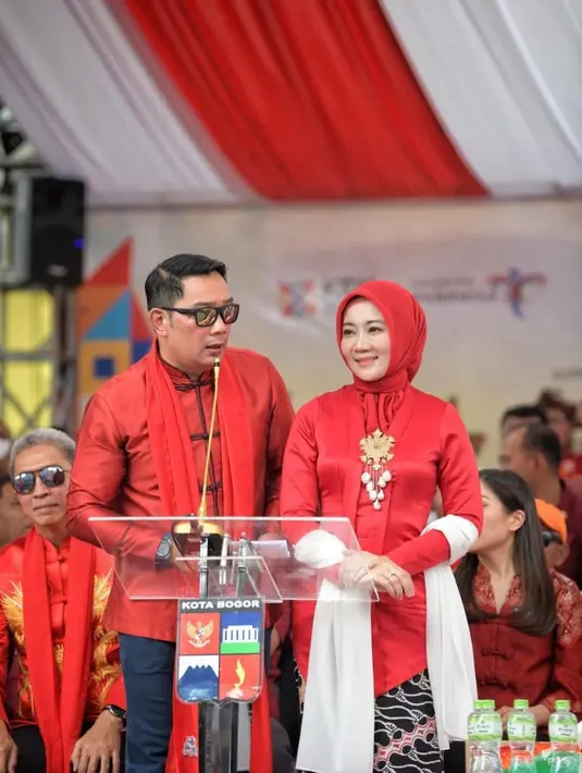 Kali ini, Atalia memamerkan potret dirinya bersama Ridwan Kamil di atas panggung. Keduanya kompak mengenakan busana berwarna merah. Atalia dengan kebaya merah polos, diberi sentuhan selendang putih dan bros emas di bagian tengah dada. Foto: Instagram.