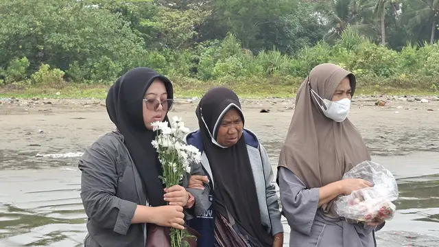 Tangis keluarga saat prosesi tabur bunga untuk jurnalis dan kru kapal hilang kontak