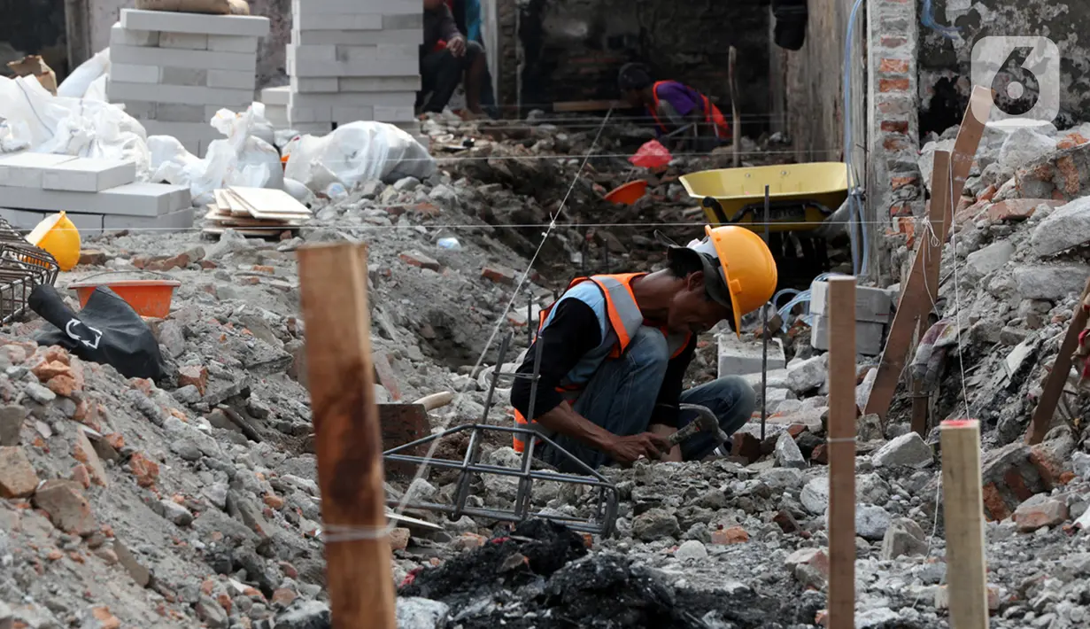 Seorang pekerja berakivitas di antara reruntuhan bangunan pasca kebakaran Pasar Gembrong di Cipinang Besar Utara, Jakarta, Senin (4/7/2022). Revitalisasi permukiman korban kebakaran Pasar Gembrong di RW 001 ini ditargetkan rampung pada September 2022 mendatang serta menelan biaya Rp7,8 miliar. (Liputan6.com/Faizal Fanani)