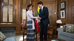 Penasehat negara Myanmar, Aung San Suu Kyi bersalaman dengan Perdana Menteri Kanada, Justin Trudeau di Parliament Hill, Ottawa, Ontario, Kanada, (7/6). Suu Kyi merupakan warga kehormatan Kanada. (Adrian Wyld/The Canadian Press via AP)