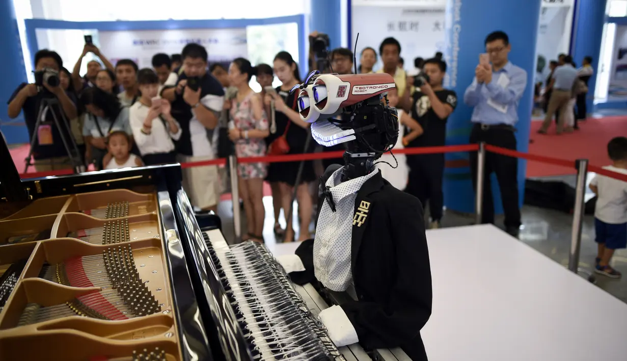 Pengunjung mengambil gambar robot "Teotronico" yang memainkan piano dalam acara Konferensi Robot Dunia 2017 di Beijing, 23 Agustus 2017. Selain memainkan piano, robot rancangan Matteo Suzzi ini juga dapat menyanyikan lagu-lagu populer. (WANG Zhao/AFP)
