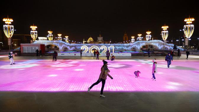 Sejumlah orang berseluncur saat pembukaan arena seluncur es di VDNKh (Pameran Prestasi Ekonomi Nasional), Moskow, Rusia, Jumat (27/11/2020). Area tersebut terbuat dari lapisan es buatan lebih dari 20.000 meter persegi. (AP Photo/Alexander Zemlianichenko)