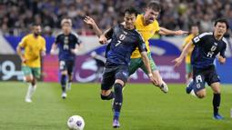 Pemain Jepang, Kaoru Mitoma (kiri) berebut bola dengan pemain Australia, Cameron Burgess saat laga lanjutan Grup C Kualifikasi Piala Dunia 2026 di Saitama Stadium, Jepang, Selasa (15/10/2024). (AP Photo/Eugene Hoshiko)