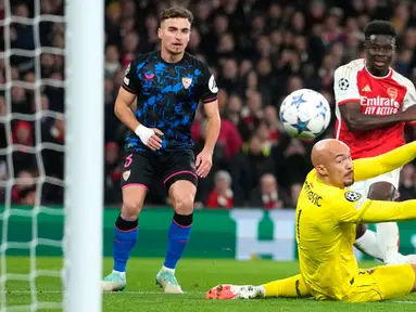 Penjaga gawang Sevilla Marko Dmitrovic melihat bola saat pemain Arsenal Bukayo Saka mencetak gol ke gawangnya pada pertandingan sepak bola Grup B Liga Champions di Emirates Stadium, London, Inggris, Rabu (8/11/2023). (AP Photo/Kirsty Wigglesworth)