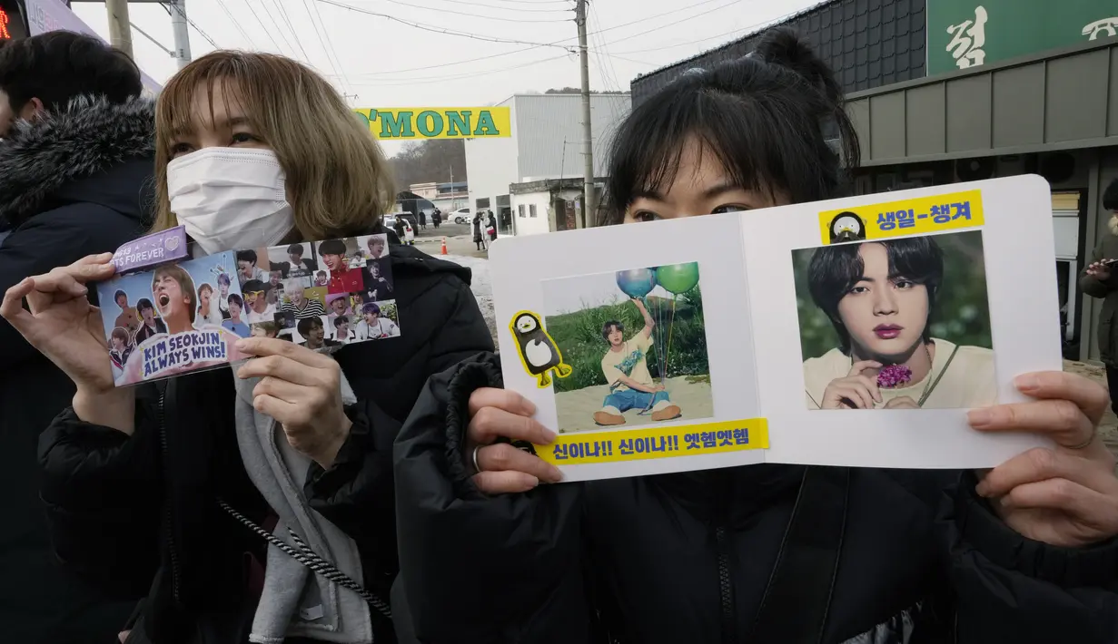 Penggemar menunggu member grup K-Pop BTS, Jin tiba sebelum memulai wajib militer untuk bertugas di depan kamp pelatihan tentara di Yeoncheon, Selasa (13/12/2022). Diketahui, Jin adalah anggota pertama BTS yang berangkat wamil, nantinya akan diikuti member lainnya seperti RM, Suga, J-Hope, Jimin, V dan Jungkook.  (AP Photo/Ahn Young-joon)