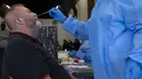 Petugas mengambil sampel lendir hidung saat tes usap COVID-19 di sebuah lokasi dekat Johannesburg, Rabu (8/12/2021). Kasus Omicron telah dikonfirmasi setidaknya di sembilan negara Afrika, dengan Afrika Selatan tetap menjadi episenter awal ditemukannya varian baru tersebut. (AP Photo/Denis Farrell)