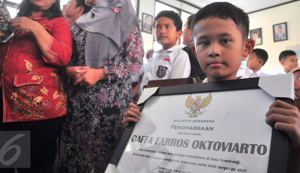 Penghargaan yang diberikan Wali Kota Semarang Hendrar Prihadi, untuk Daffa Farros Oktoviarto di SD Kalibanteng 01, Semarang, Rabu (20/4). Daffa menjadi perbincangan di medsos karena aksinya menghadang pengendara yang melintas di trotoar. (Foto: Gholib)