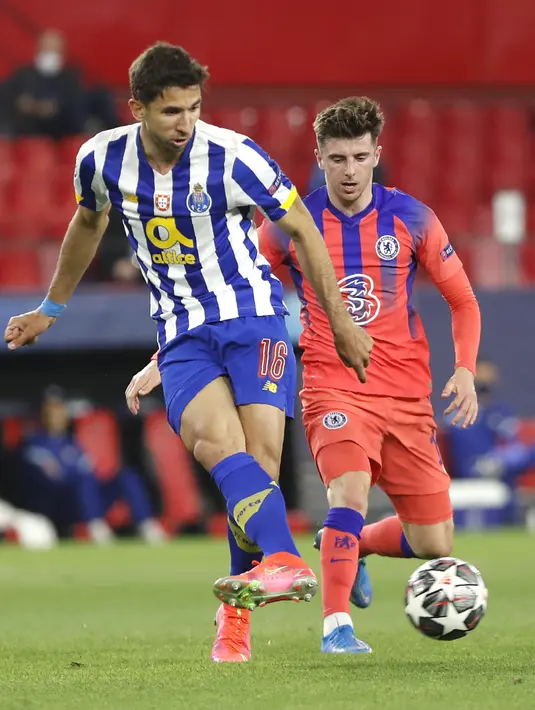 Gelandang FC Porto, Marko Grujic menendang bola di depan gelandang Chelsea, Mason Mount a pada leg pertama perempat final Liga Champions, Kamis (8/4/2021). Chelsea menang 2-0 Porto di laga yang digelar di tempat netral tersebut. (AP Photo/Angel Fernandez)