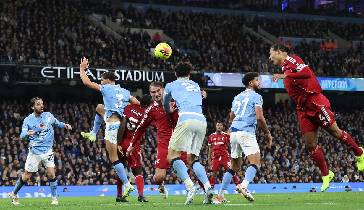 Pemain Liverpool, Virgil van Dijk, melepaskan tandukan kepala ke gawang Manchester City pada lanjutan Liga Inggris di Etihad Stadium, Minggu (09/11/2025) malam WIB. (AFP/Darren Staples)