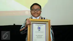 Jefri Setiawan berpose usai menerima penghargaan dari Official World Record di Auditorium Kemenpora, Jakarta, Kamis (14/11). Jefri mencatat rekor dunia baru memainkan 60 lagu menggunakan keyboard dengan mata tertutup. (Liputan6.com/Helmi Fithriansyah)