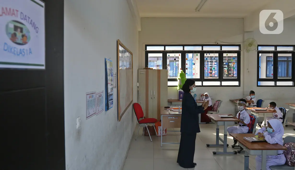 Guru memberikan materi saat uji coba pembelajaran tatap muka (PTM) di SDN 05 Kalisari, Jakarta, Senin (30/8/2021). Pemprov DKI  menggelar PTM di tengah pandemi covid-19 mulai 30 Agustus 2021 secara terbatas dengan kapasitas 50 persen pada setiap satuan pendidikan. (Liputan6.com/Herman Zakharia)