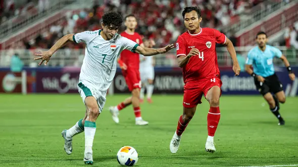 <p>Pemain Timnas Indonesia U-23, Komang Teguh Trisnanda (kanan) membayangi pergerakan pemain Irak U-23, Ali Jasim pada laga perebutan tempat ketiga Piala Asia U-23 2024 di Abdullah bin Khalifa Stadium, Doha, Qatar, Kamis (2/5/2024). (AFP/Karim Jaafar)</p>