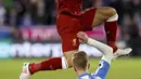 Aksi Mohamed Salah (atas) menghindari terjangan pemain Huddersfield Town, Florent Hadergjonaj pada lanjutan Premier League di John Smith's Stadium, Huddersfield, (30/1/2018). Liverpool menang 3-0. (Martin Rickett/PA via AP)