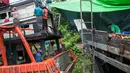 Para pekerja saat memperbaiki sebuah kapal di galangan kapal di tepi Sungai Yangon, yang terletak di pinggiran Yangon, Myanmar (30/7/2019). (AFP Phot/Sai Aung Main)