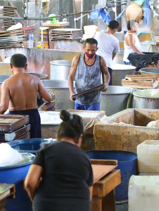 Perajin tahu memproduksi tahu berbahan kedelai di Jakarta, Senin (4/1/2021). Setelah melakukan mogok produksi selama 1 hingga 3 Januari 2021 akibat naiknya harga kacang kedelei impor, kini para perajin tahu mulai kembali beroperasi. (Liputan6.com/Angga Yuniar)