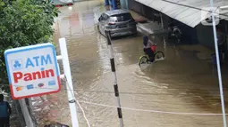 Aktivitas warga saat banjir merendam sejumlah pertokoan di sekitar Jalan Gunung Sahari, Jakarta, Selasa (25/2/2020). Hujan yang mengguyur Jakarta sejak Senin (24/2/2020) malam, membuat sejumlah kali meluap dan menyebabkan banjir. (Liputan6.com/Helmi Fithriansyah)