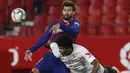 Bek Barcelona, Gerard Pique, berebut bola dengan pemain Sevilla, Jules Kounde, dalam laga lanjutan La Liga Spanyol, Sabtu (20/6/2020) dini hari WIB. Barcelona bermain imbang 0-0 atas Sevilla. (AP/Angel Fernandez)