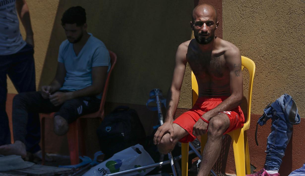 Pemuda Palestina yang diamputasi beristirahat selama latihan renang di bawah instruksi Majdi al-Tatar di Kota Gaza (30/7/2019). Tatar, yang kehilangan kaki kanannya akibat kecelakaan pada masa kecilnya, melatih warga Palestina yang diamputasi selama konflik dengan Israel. (AFP Photo/Mahmud Hams)