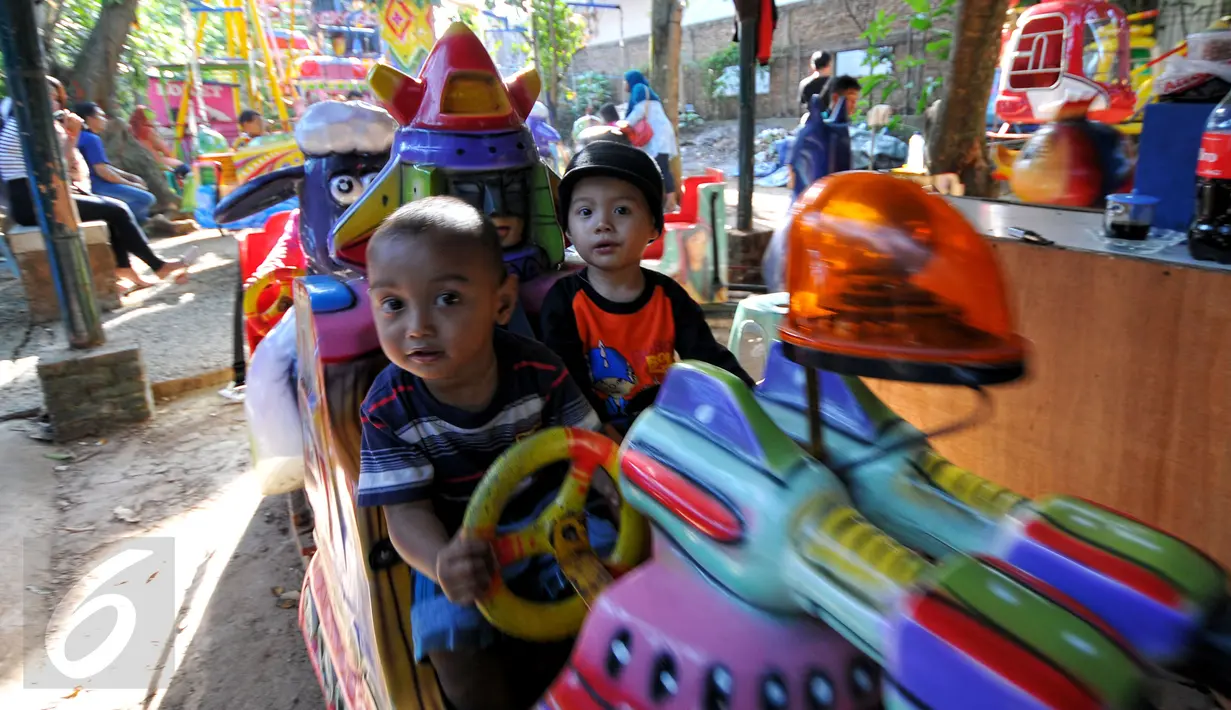 Para bocah tampak asyik menaiki mobil-mobilan di Kampung Budaya Betawi, Sabtu (18/7/2015). Kampung ini menghadirkan beragam pagelaran seni dan aneka permainan yang baik untuk edukasi keluarga. (Liputan6.com/Yoppy Renato)