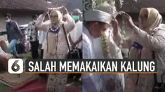 Bukannya memakaikan kalung ke mempelai pria, ibu-ibu ini justru memakai kalung sendiri saat tradisi pernikahan berlangsung.