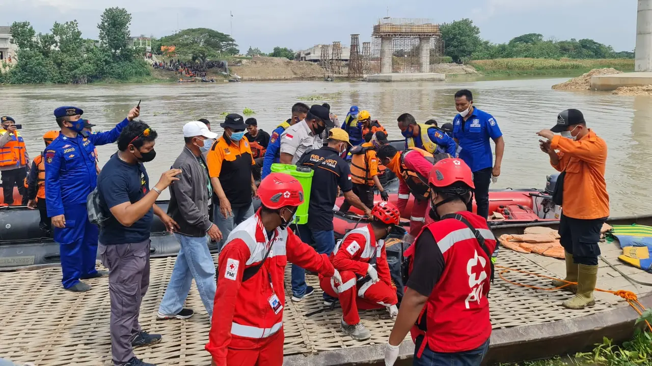 Petugas mengevakuasi korban perahu tenggelam di Bengawan Solo. (Ahmad Adirin/Liputan6.com)