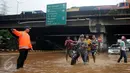 Warga membantu mendorong motor yang mogok saat berusaha menerobos banjir di Jalan Raya Kalimalang, Caman, Bekasi, Senin (20/2). Imbas banjir, ruas Jalan Kalimalang dari arah Jakarta menuju Bekasi dan sebaliknya ditutup (Liputan6.com/Gempur M Surya)