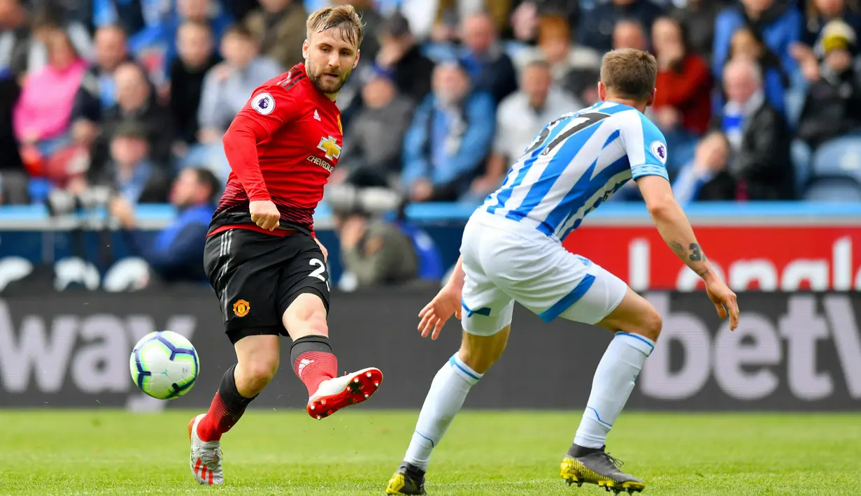 Bek kiri Manchester United, Luke Shaw berebut bola dnegan pemain Huddersfield Town, Erik Durm pada pekan ke-37 Liga Inggris di John Smith's Stadium, Minggu (5/5/2019). MU gagal ke Liga Champions musim depan setelah ditahan Huddersfield Town dengan skor 1-1. (Anthony Devlin/PA via AP)