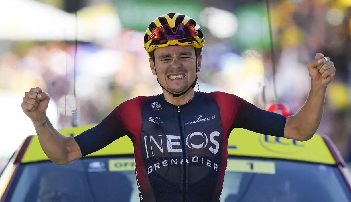 Pebalap tim Ineos Grenadiers, Thomas Pidcock melakukan selebrasi saat melintasi garis finis pada Stage 12 Tour de France 2022 yang menempuh rute sepanjang 165,1 km dari Briancon hingga L'Alpe-d'Huez, di Pegunungan Alpen, Prancis, Jumat (14/07/2022). (AP/Thibault Camus)
