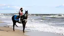 Seorang warga yang menunggang kuda berdoa bagi mereka yang tewas dalam gempa bumi dan tsunami 2011 di Minamisoma, Prefektur Fukushima, Jepang, Rabu (11/3/2020). Gempa 9,0 magnitudo yang menyebabkan tsunami pada 11 Maret 2011 itu menyebabkan sekitar 15 ribu orang tewas. (Kyodo News via AP)
