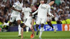 Pemain Manchester City, Erling Haaland (kanan kedua) terjatuh saat berebut bola dengan pemain Real Madrid, Eduardo Camavinga (kanan) dan Nacho pada laga leg pertama semifinal Liga Champions 2022/2023 di Santiago Bernabeu, Madrid, Rabu (10/05/2023) WIB. Laga berakhir dengan skor 1-1. (AP Photo/Manu Fernandez)