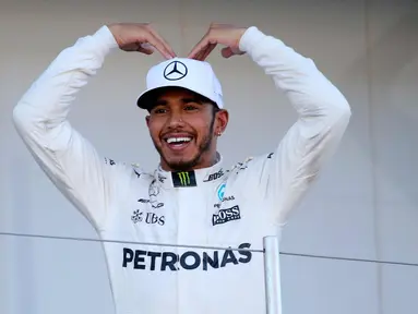 Pembalap F1 dari tim Mercedes Lewis Hamilton dari Inggris berpose di atas podium usai memenangkan GP F1 Jepang di Sirkuit Suzuka, Jepang, (8/10). Dengan kemenangan ini, Hamilton menjauh dari Sebastian Vettel di klasemen F1. (AP Photo / Toru Takahashi)