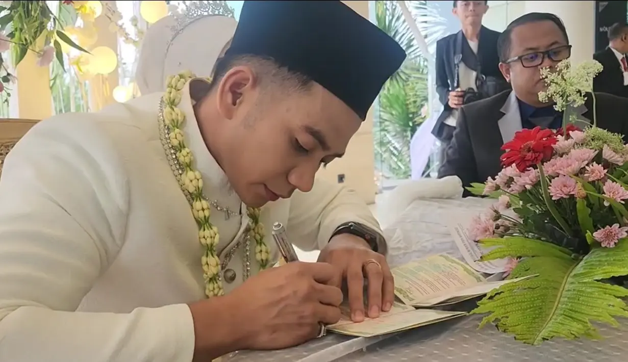 Prosesi akad nikah di gelar pada Sabtu (9/12). Pria seorang anak itu tampak mengenakan busana pengantin warna putih. Begitu juga sang istri yang tampil cantik berhijab. [Instagram/da2_rizki123]