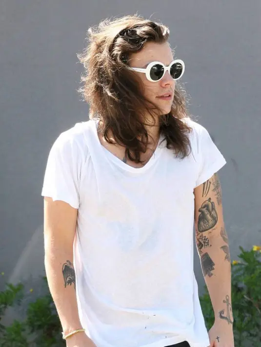 Buat Harry Styles, ganteng nggak perlu sulit. Cukup pakai kaus putih dan juga kacamata hitam, dia terlihat sempurna banget! (Phoenix/AKM-GSI)